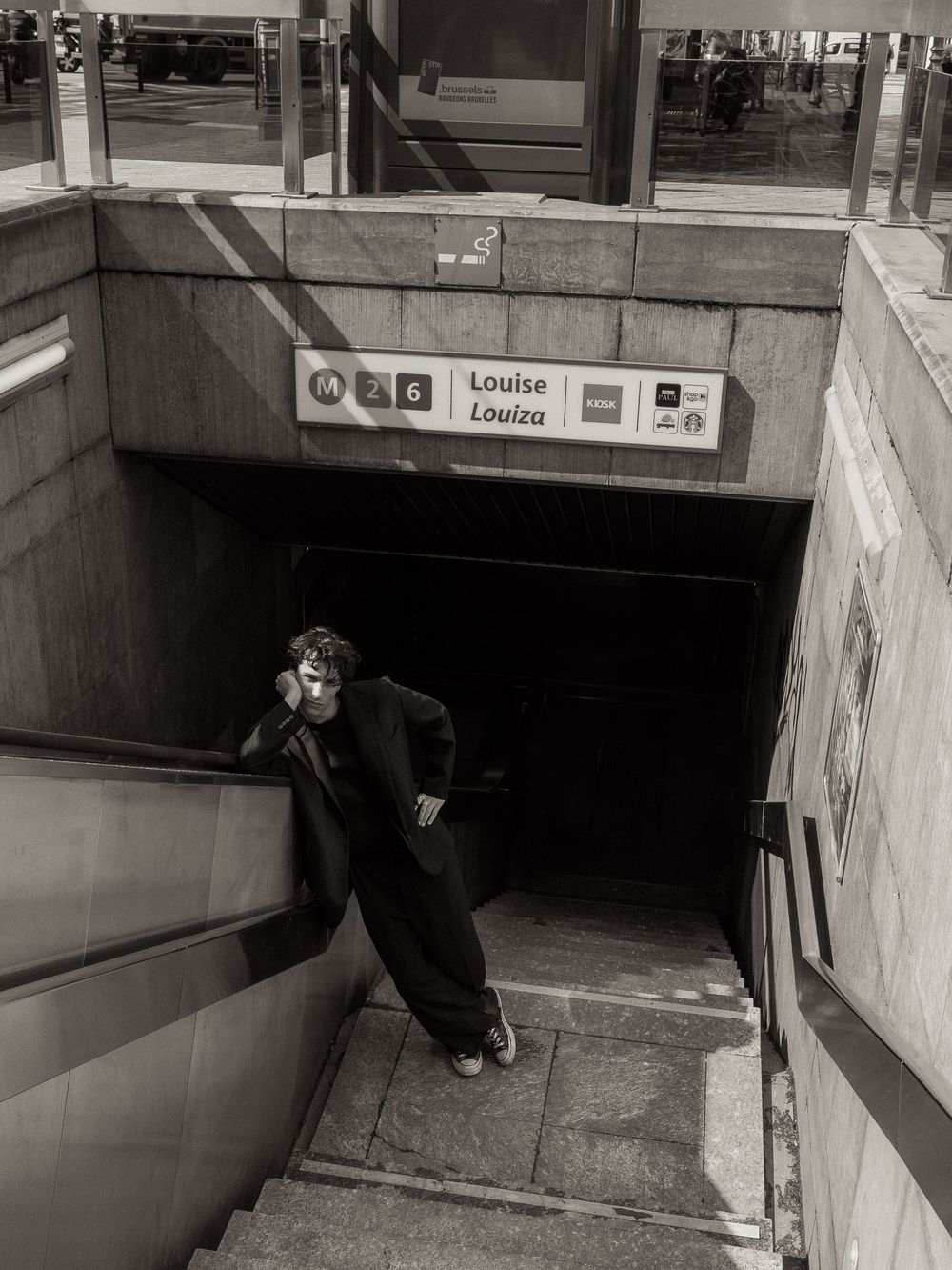 Black and white photo of a person exiting Louise metro station in Brussels, Belgium.