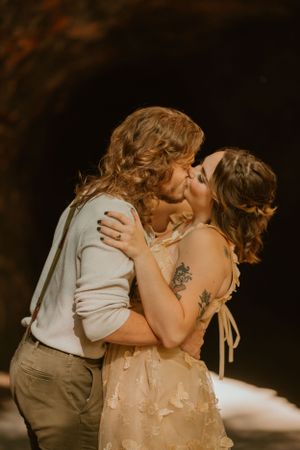 The couple share a passionate kiss in front of a cave at their elopement ceremony in Kentucky.