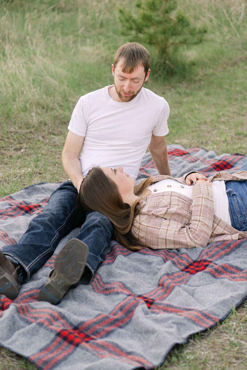 Couple sitting in a quiet field at sunset during an editorial-inspired engagement session near St. Paul, MN