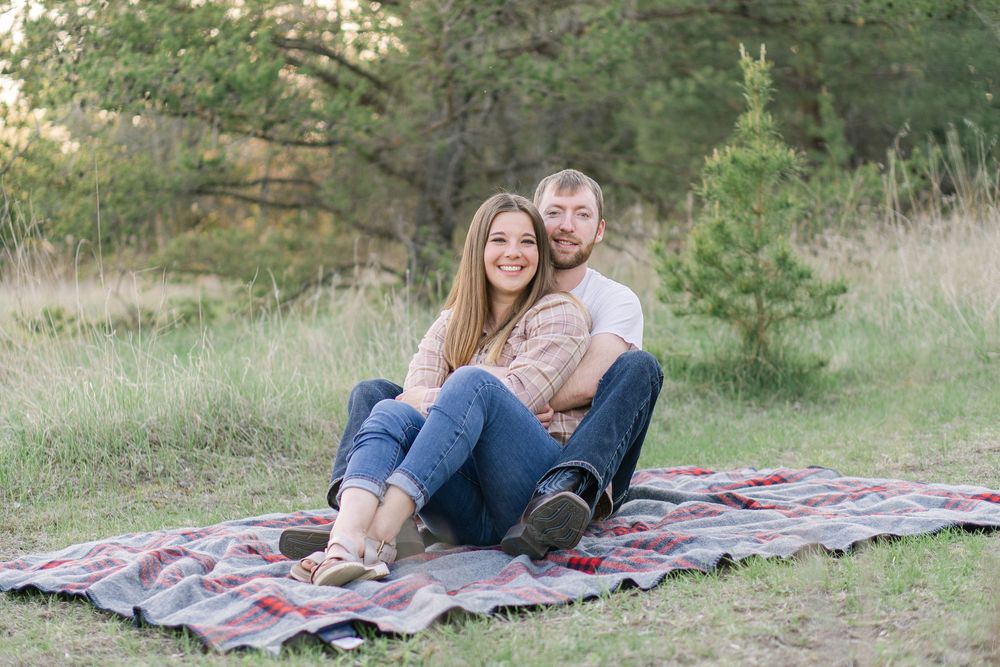 Couple smiling and laughing in a quiet field at sunset during an editorial-inspired engagement session near St. Paul, MN