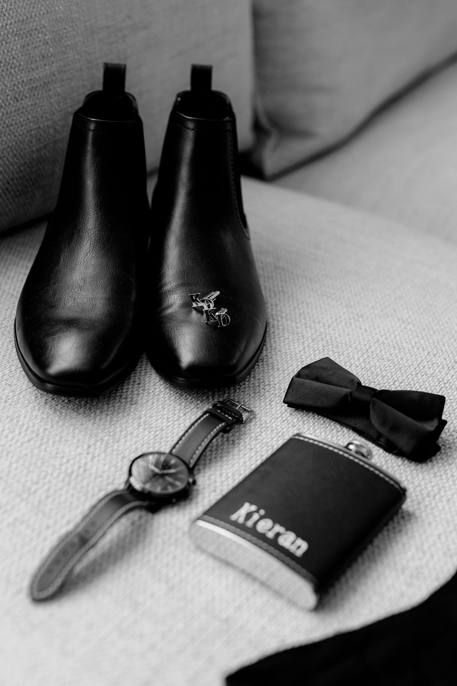 A series of black and white minimalist photos showing sleek leather dress shoes with wallet accents on light fabric.