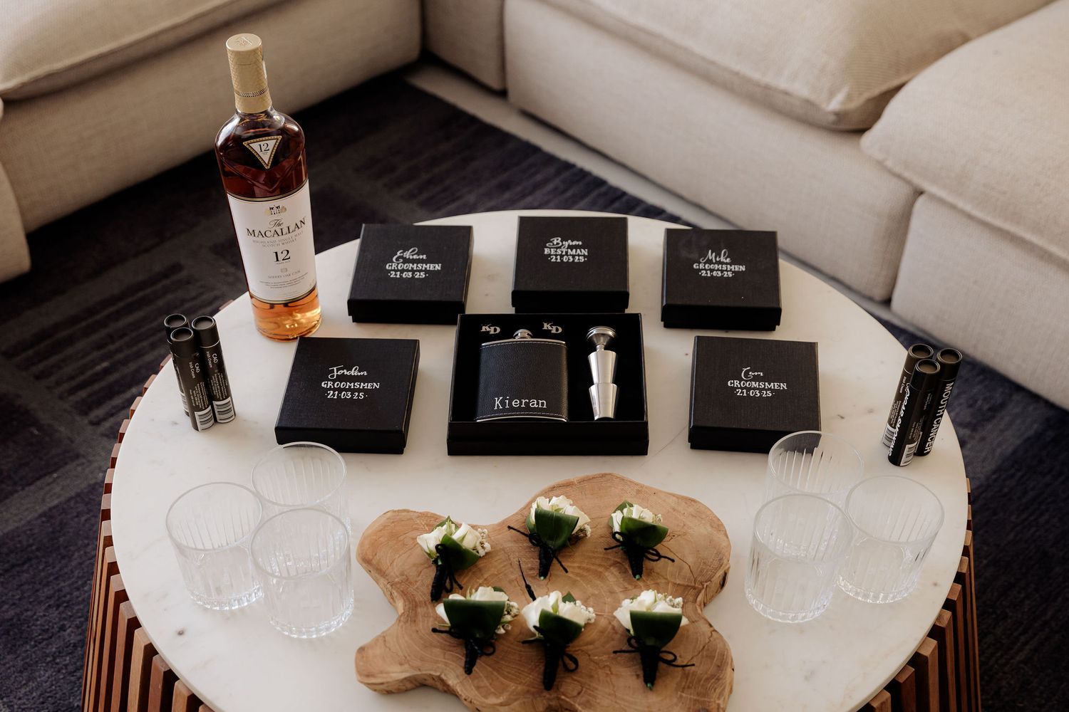 Elegant table settings with signature black gift boxes, cocktail glasses, and delicate appetizers on marble surfaces.