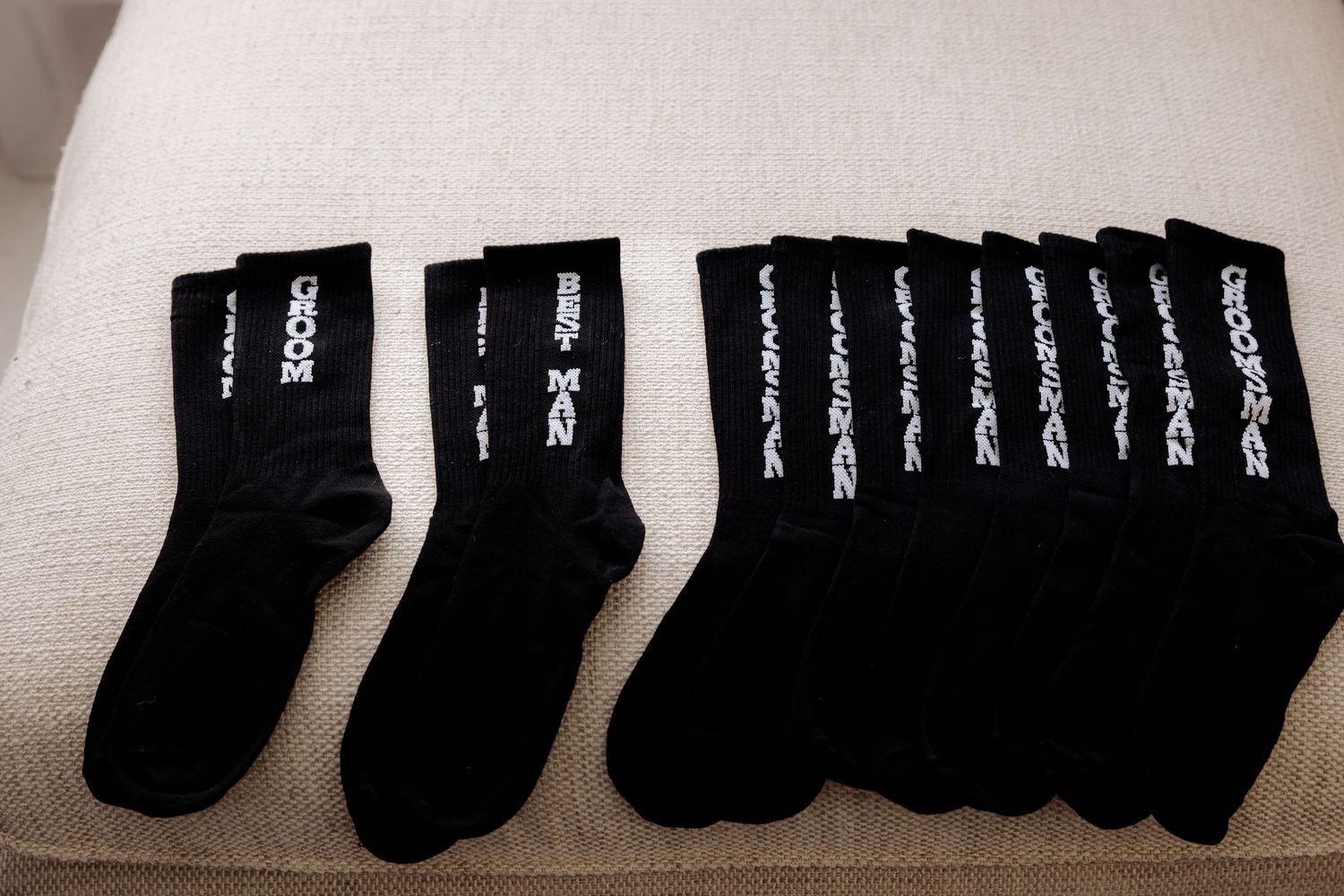 Compact black socks neatly arranged in a series of four organized rows against a white surface.
