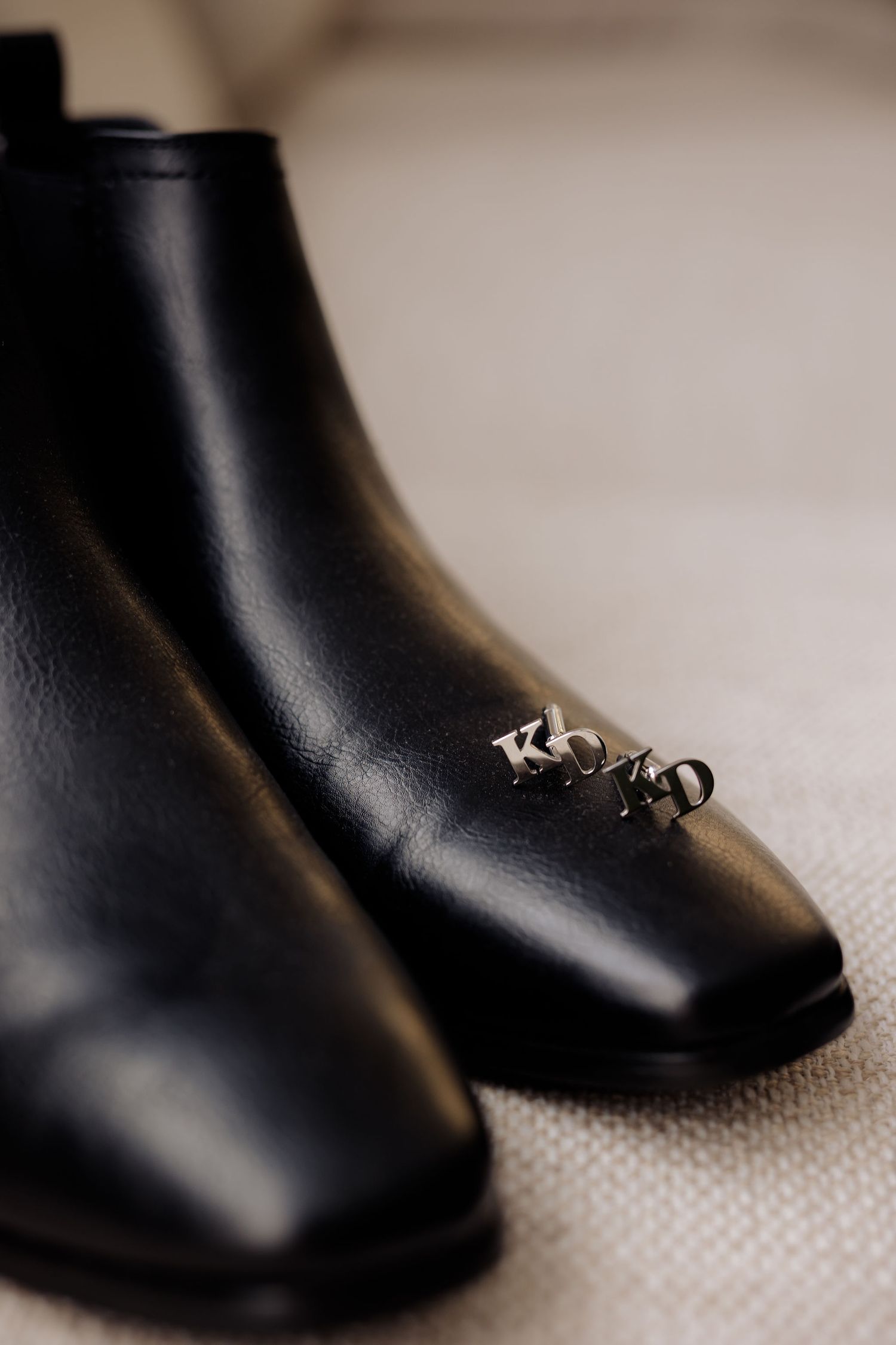 Multiple close-up views of a sleek black leather boot shown at different angles and depths of field.