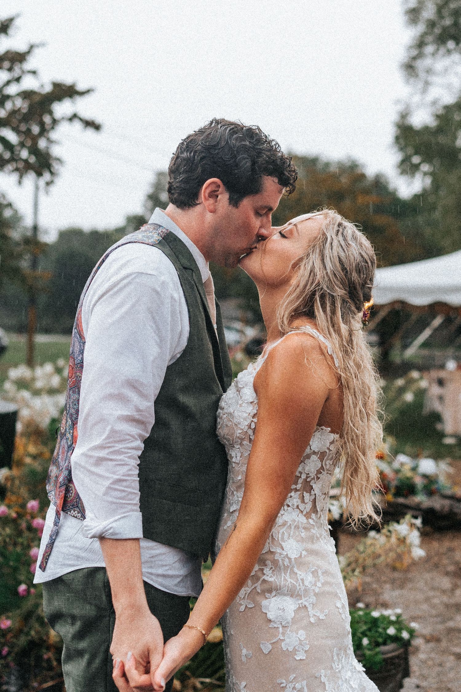 Intimate wedding moment captured in garden setting with vintage-inspired attire.