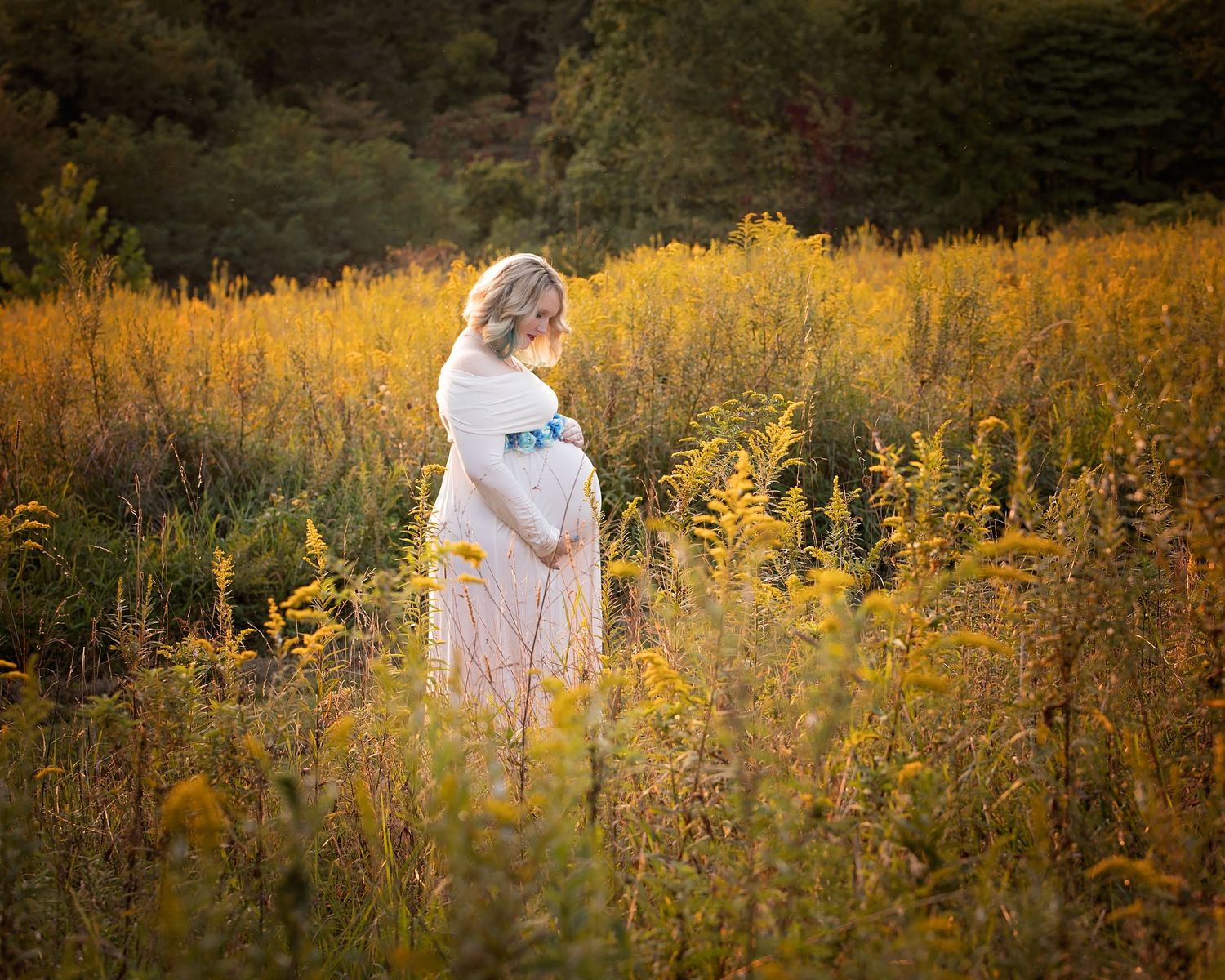 Figure walking through a field of vibrant yellow wildflowers at golden hour.