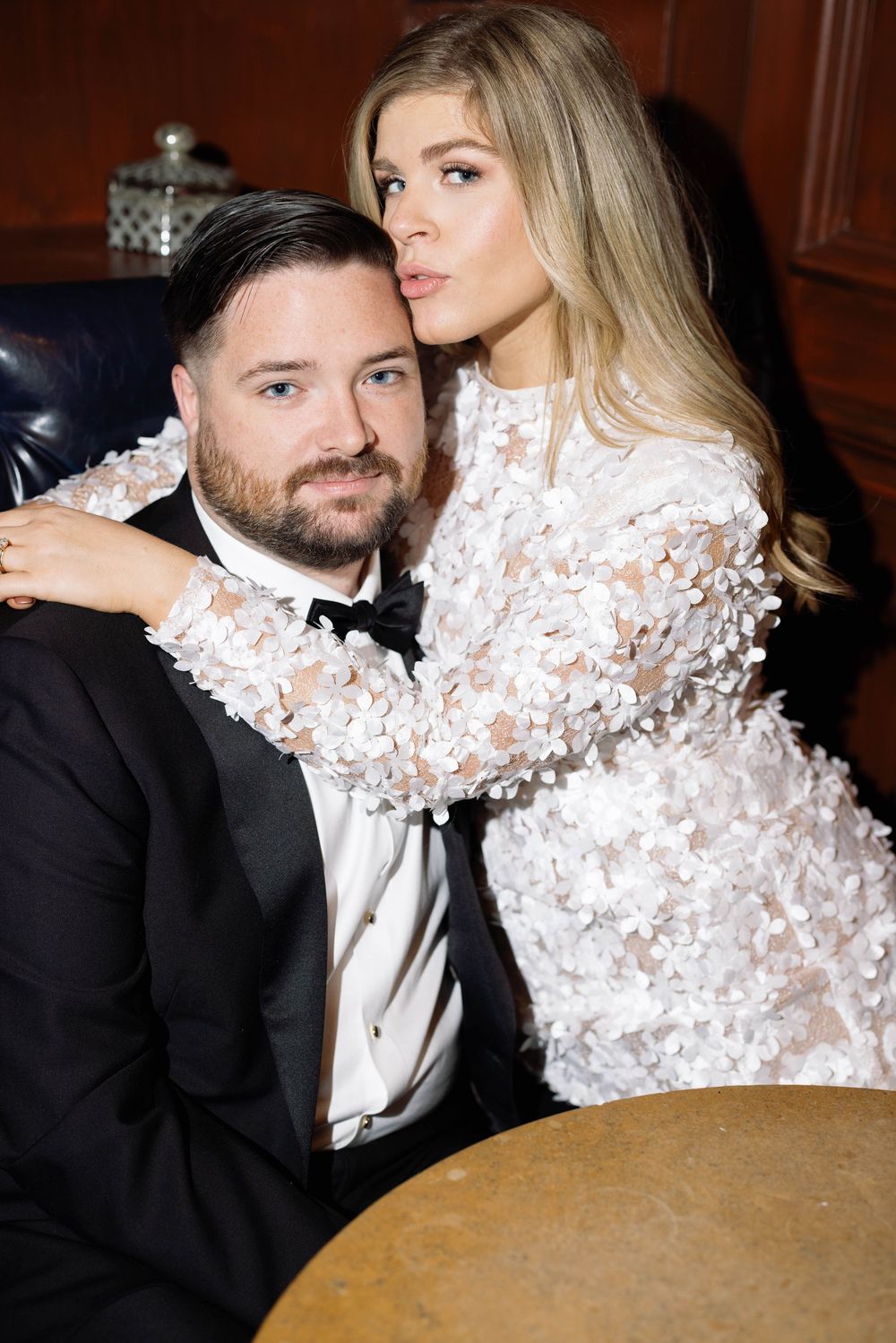 Stylish couple in evening wear sharing intimate moments at an upscale venue.