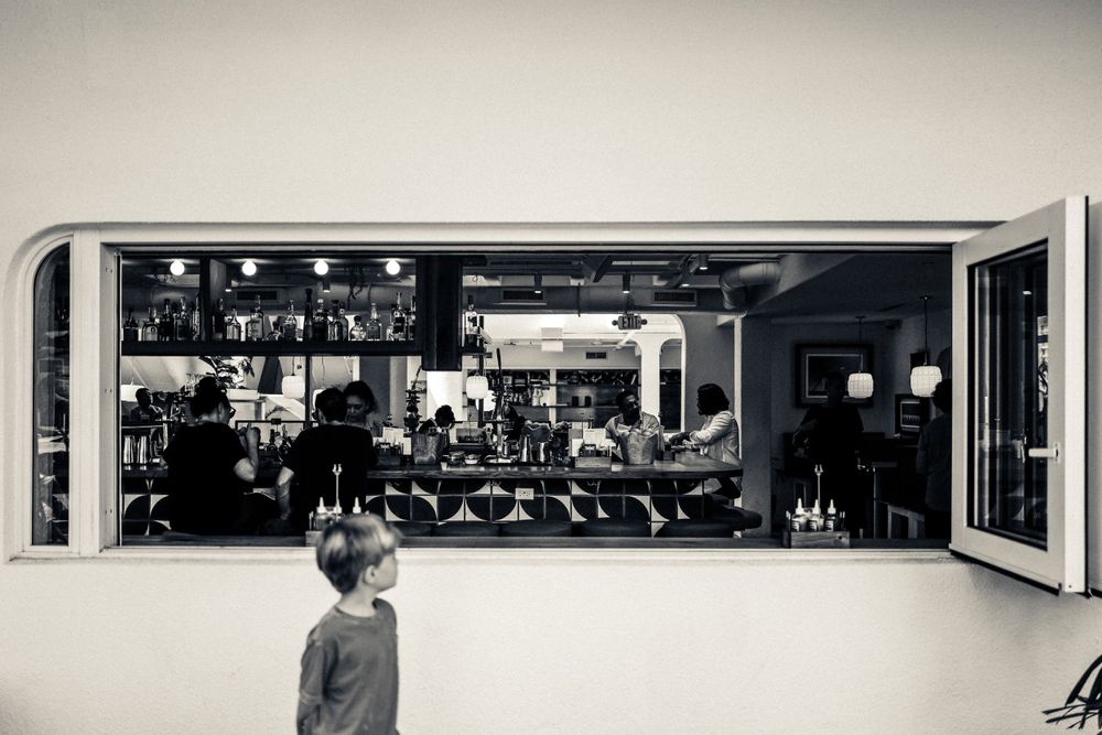 A black and white view through a window showing a storefront display with merchandise.