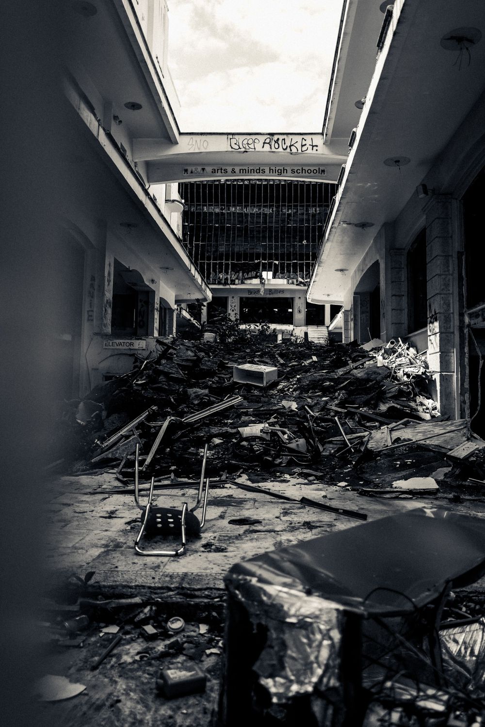 A destroyed abandoned mall interior filled with debris and rubble.