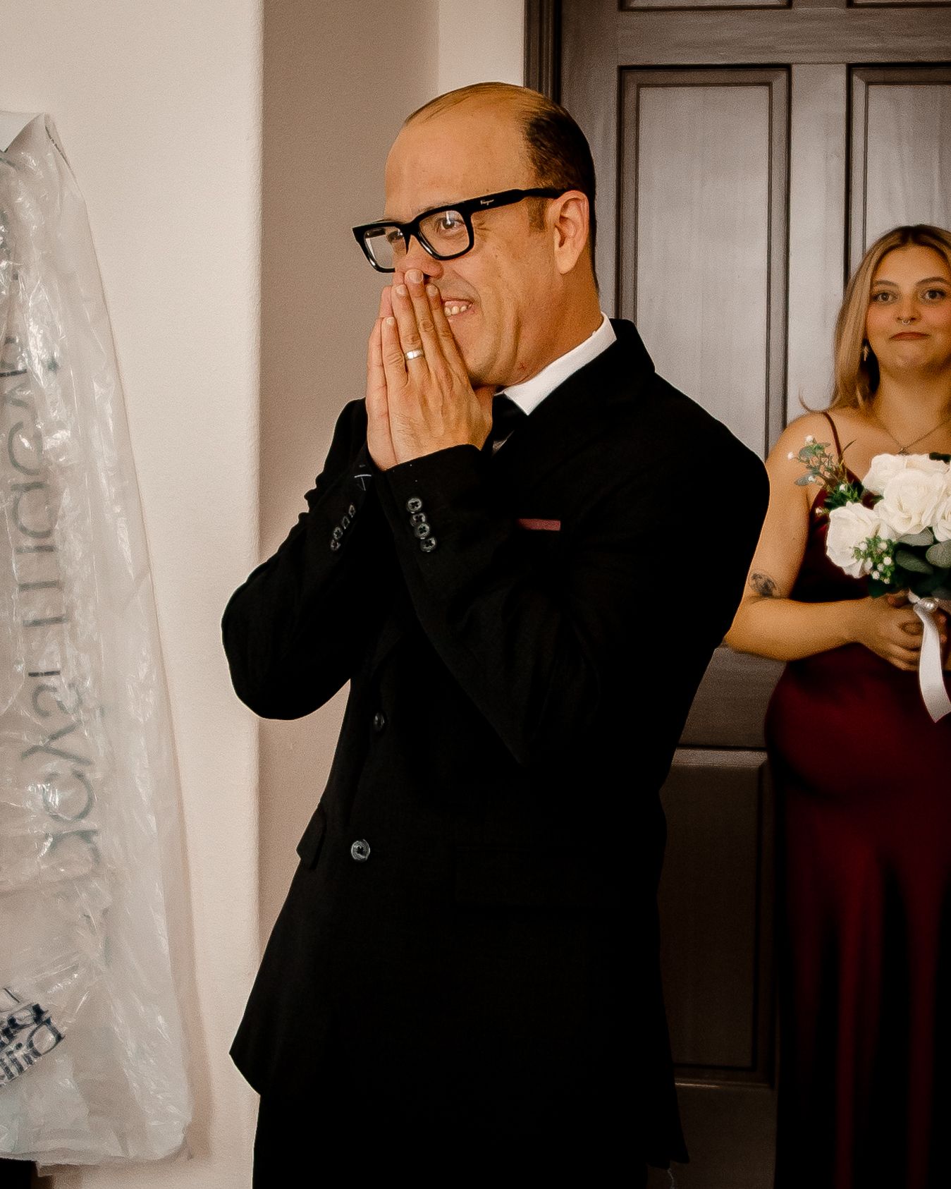 An emotional father wipes tears away during a first look moment at a wedding.