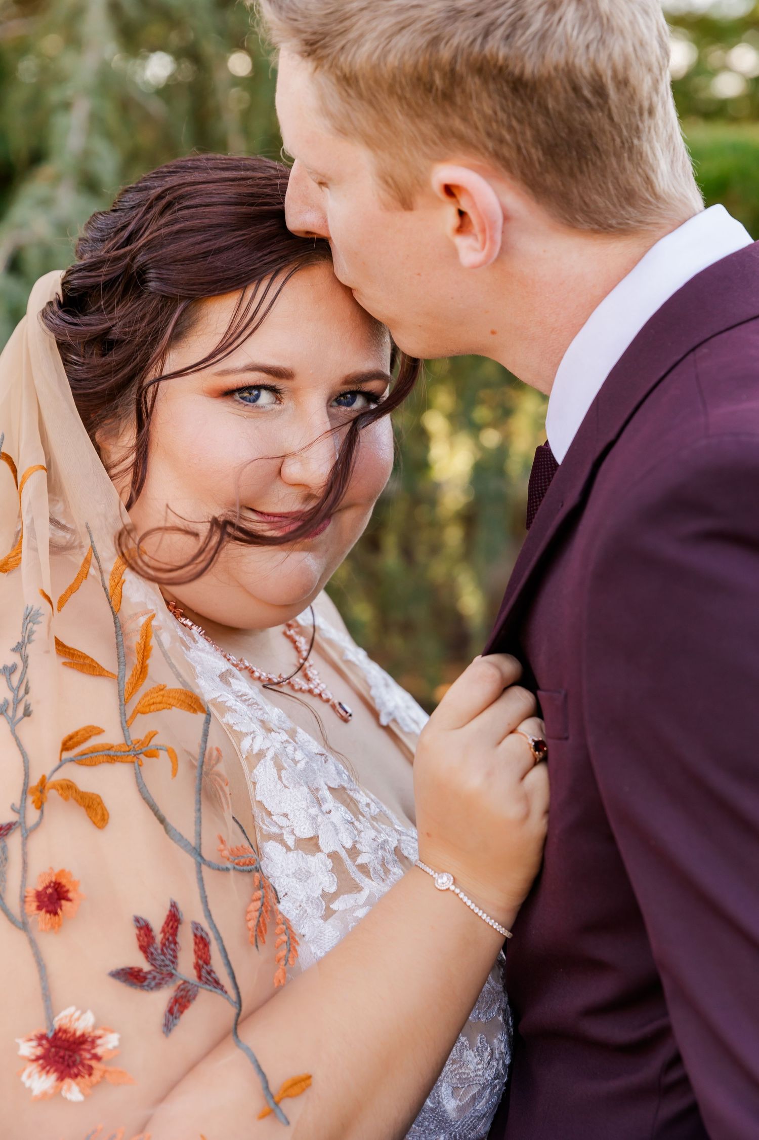 Romantic moment shared between newlyweds outdoors with soft autumn lighting.