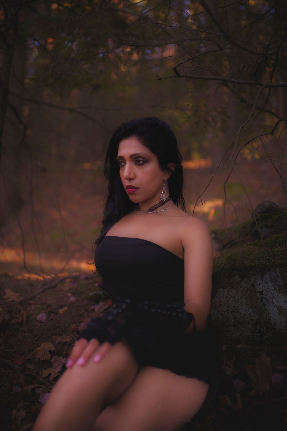 Autumn forest portrait with warm lighting and dark elegant attire.