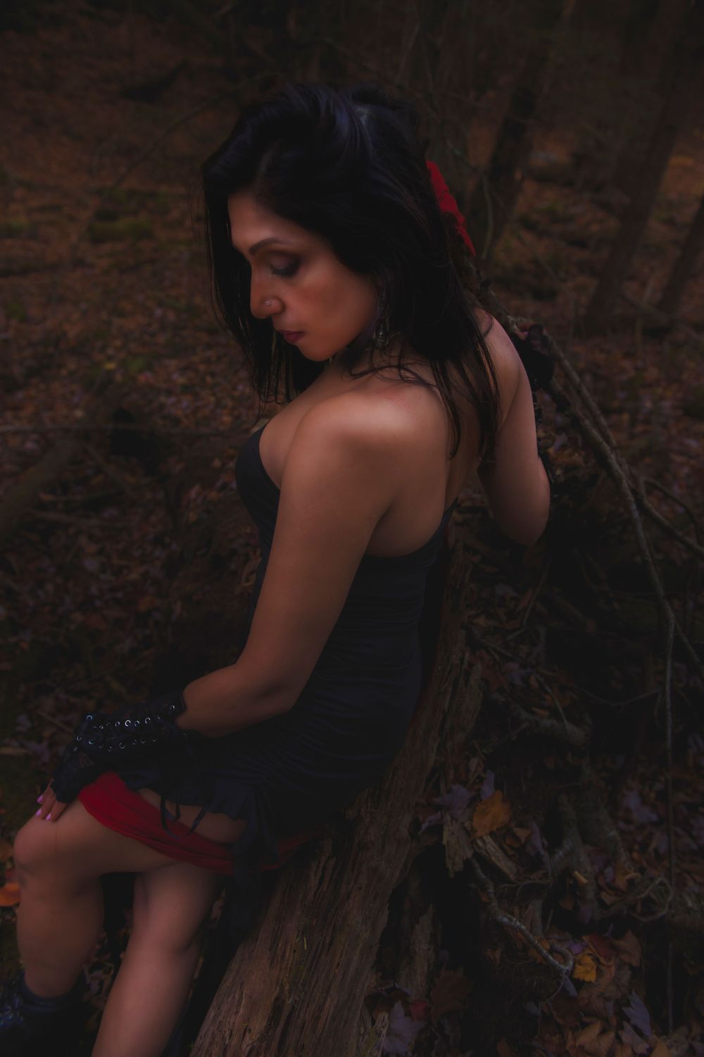 Moody forest portrait with black dress and dramatic shadowing.