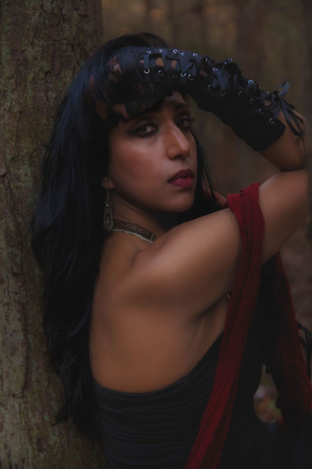 Gothic-inspired forest portrait with black lace accessories and dramatic makeup.