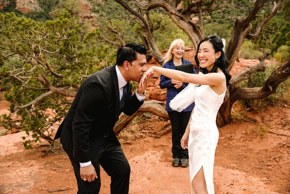 A celebratory moment during an outdoor wedding ceremony with Sedona desert landscape in the background.