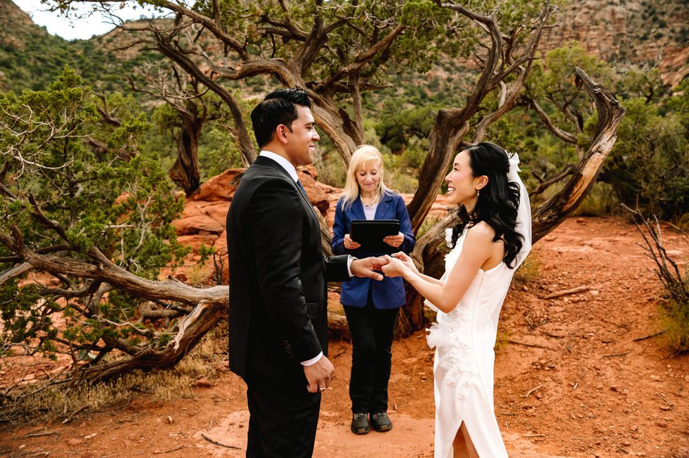 An intimate wedding ceremony takes place on a desert trail with stunning Sedona rock formations in view.