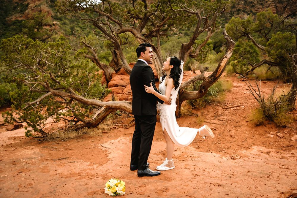 A couple dances during their outdoor wedding celebration with Sedona desert scenery in the background.