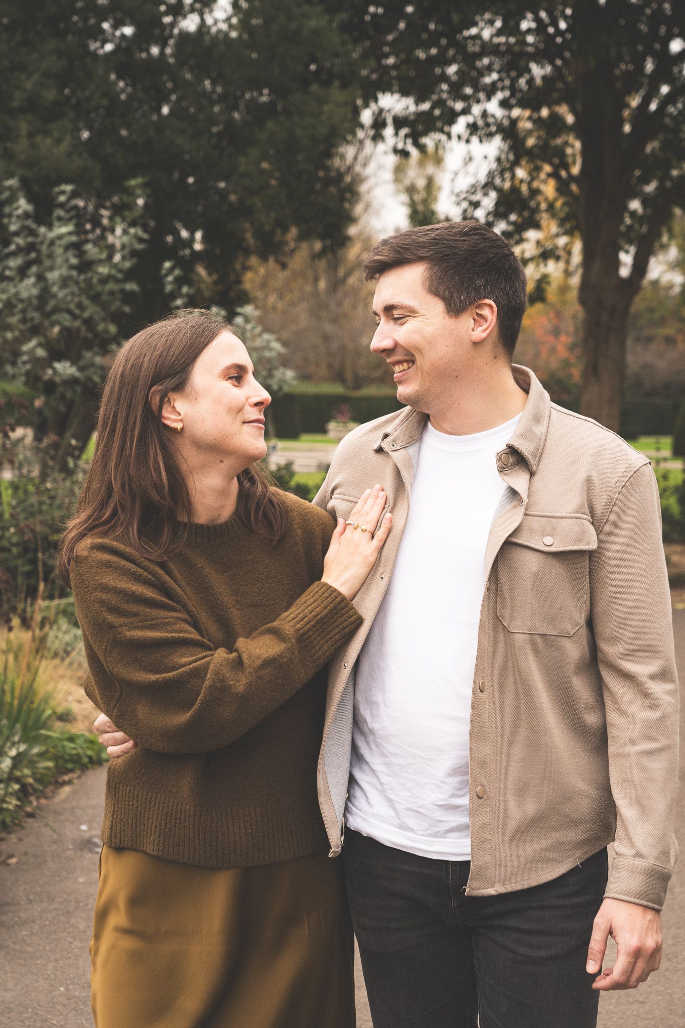 Couple shares playful moments in autumn park setting.