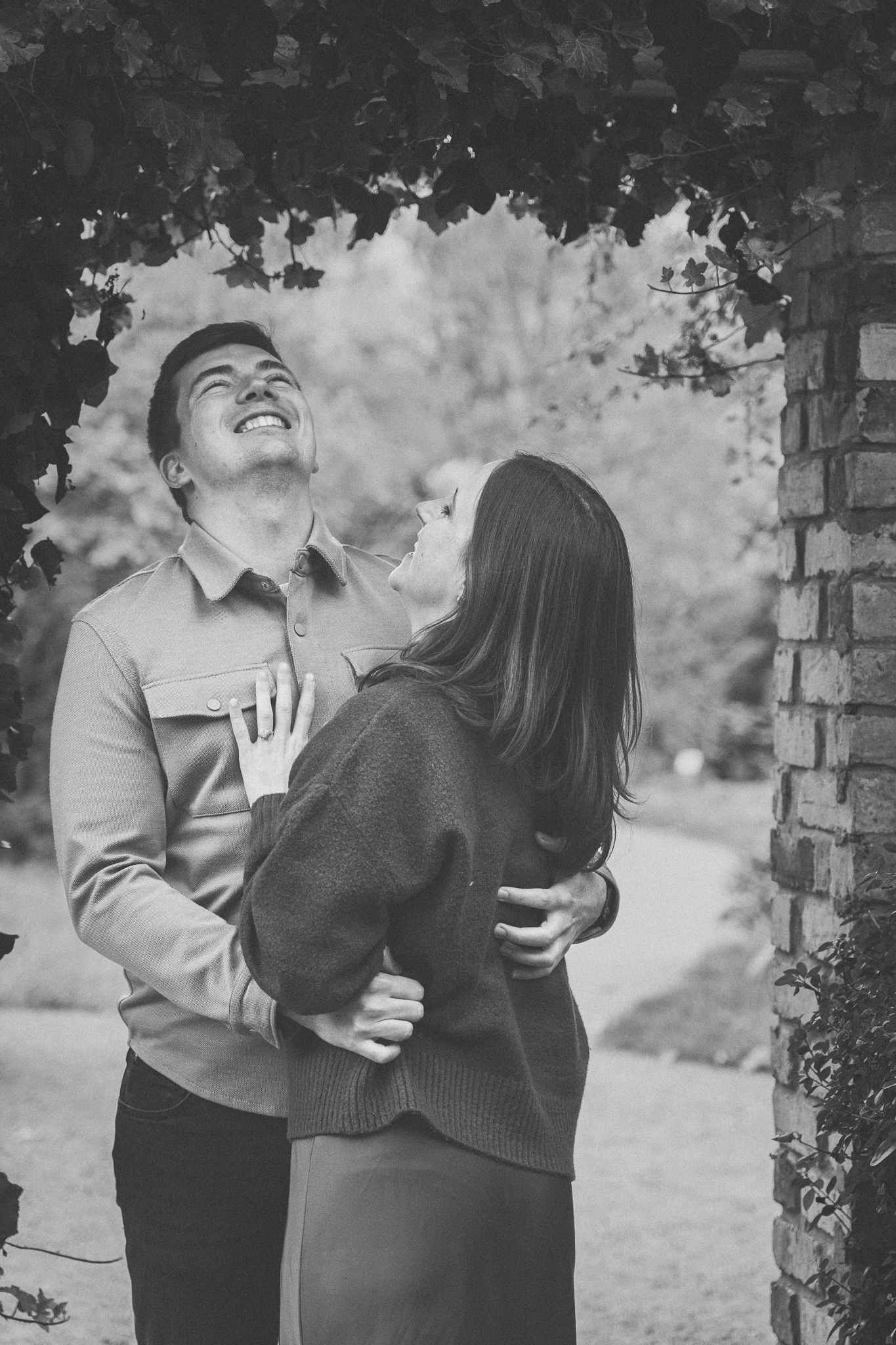 A black and white sequence of a couple sharing an intimate moment in a garden setting.