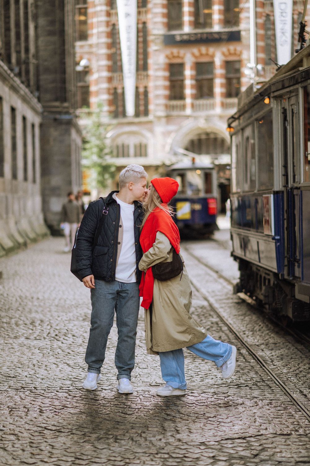 Romantic couple walking together on a historic cobblestone path.
