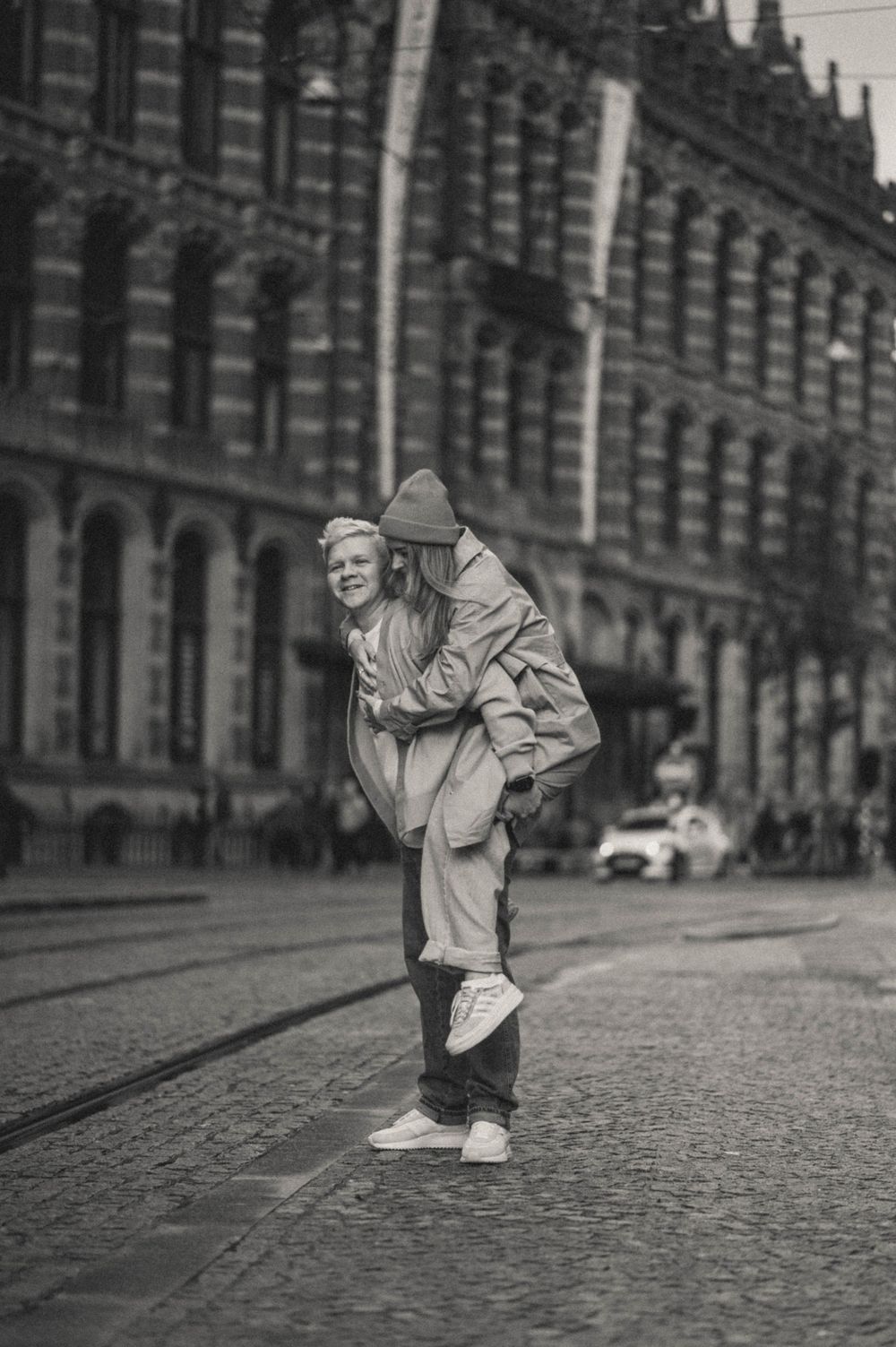 Black and white photos of a person walking on a vintage cobblestone street.