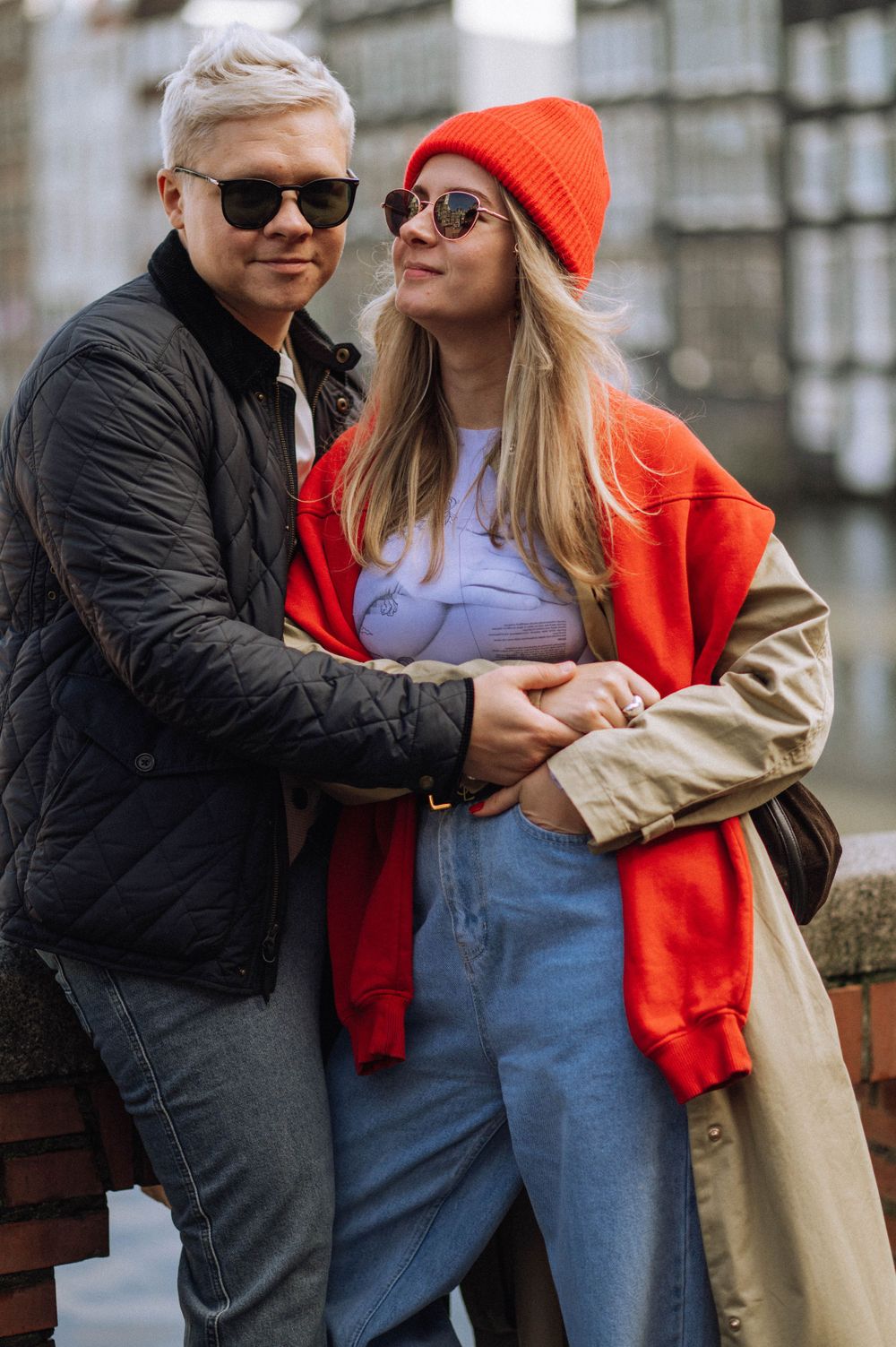 A couple in casual wear sharing intimate moments on a cobblestone street.