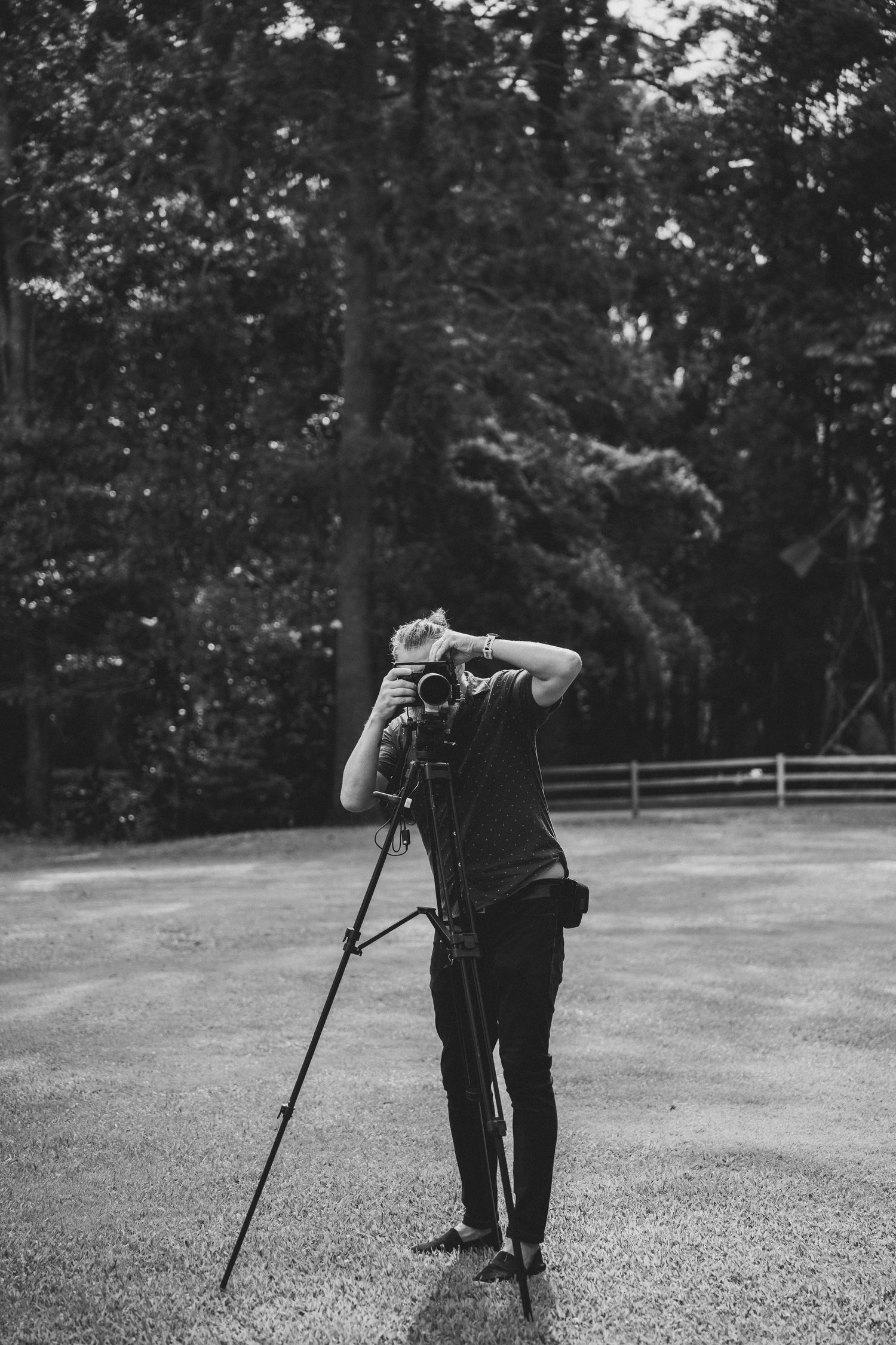 A series of black and white photos showing someone walking with a cane across a grassy area near a fence.