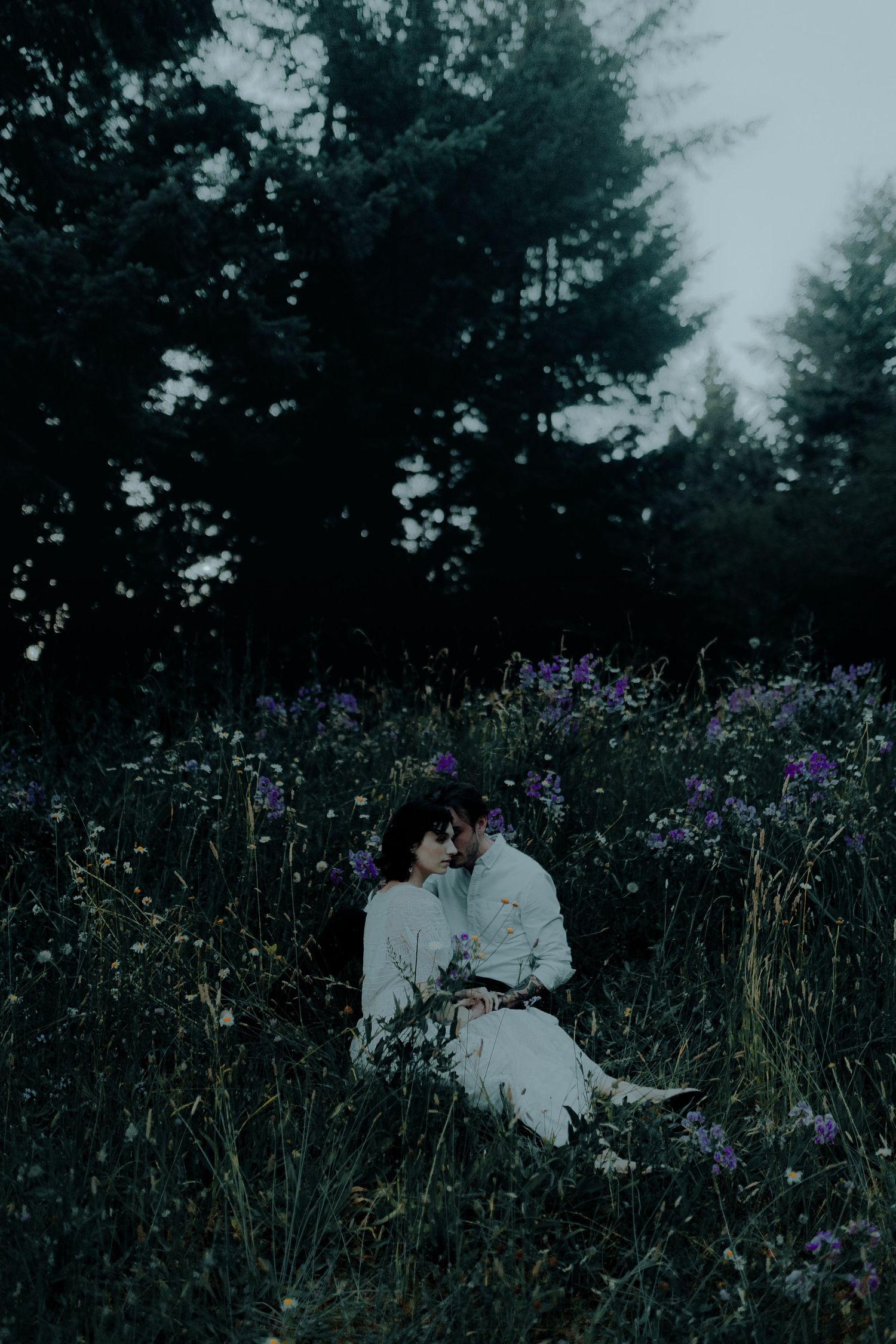 Intimate moment captured in a field of purple wildflowers at dusk.