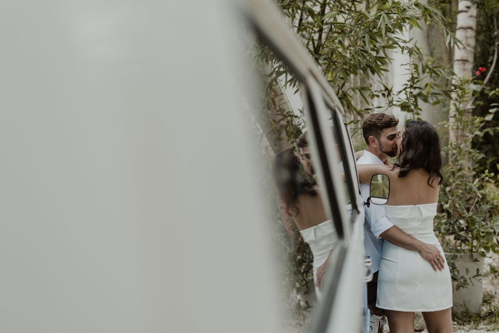 A tender embrace captured through foliage against a blurred background.