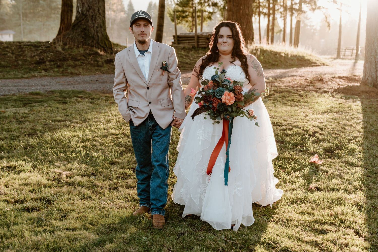 Wedding party poses in grassy field during golden hour sunset.