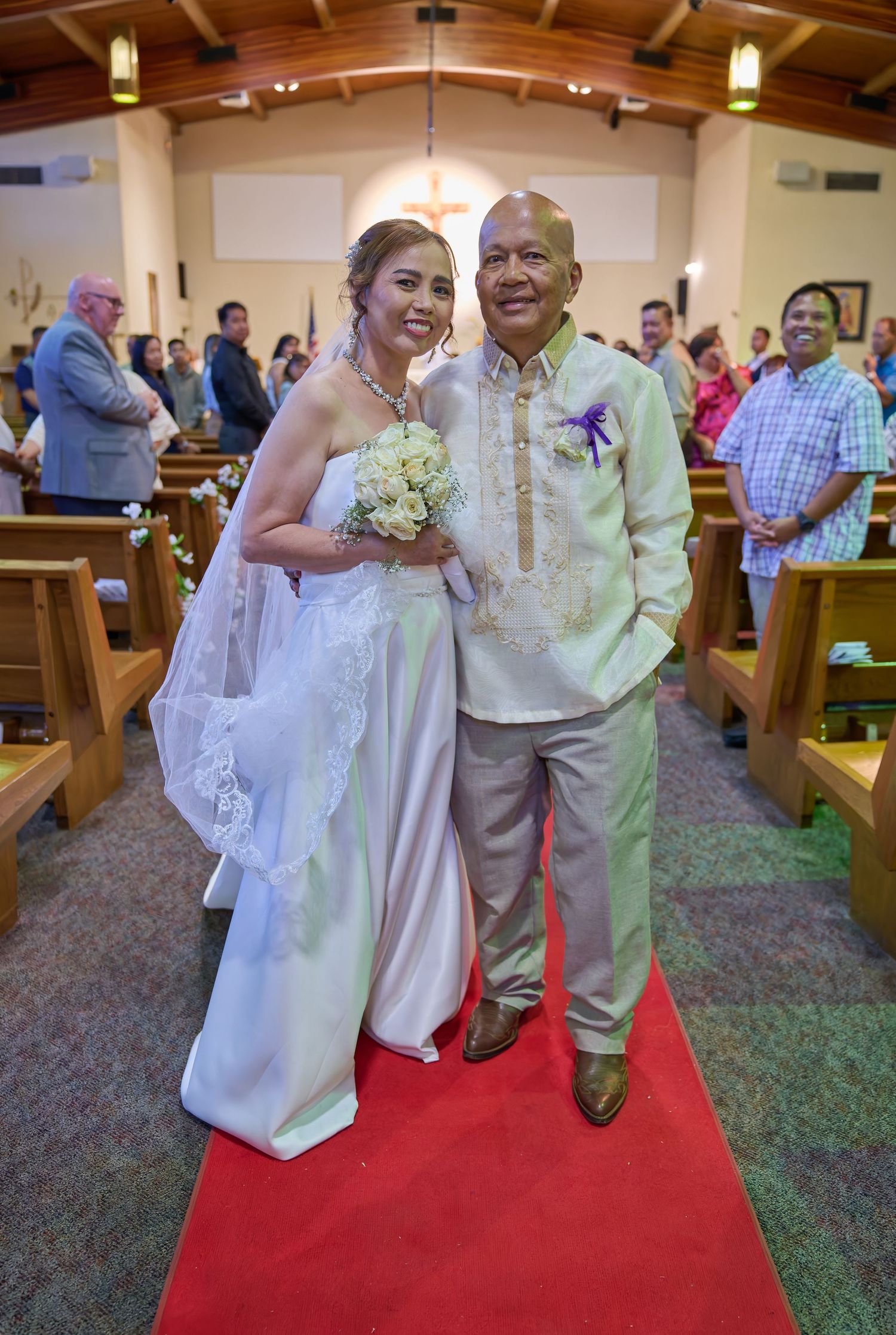 Newlyweds share a romantic kiss at altar surrounded by purple decor and yellow flowers during wedding ceremony.