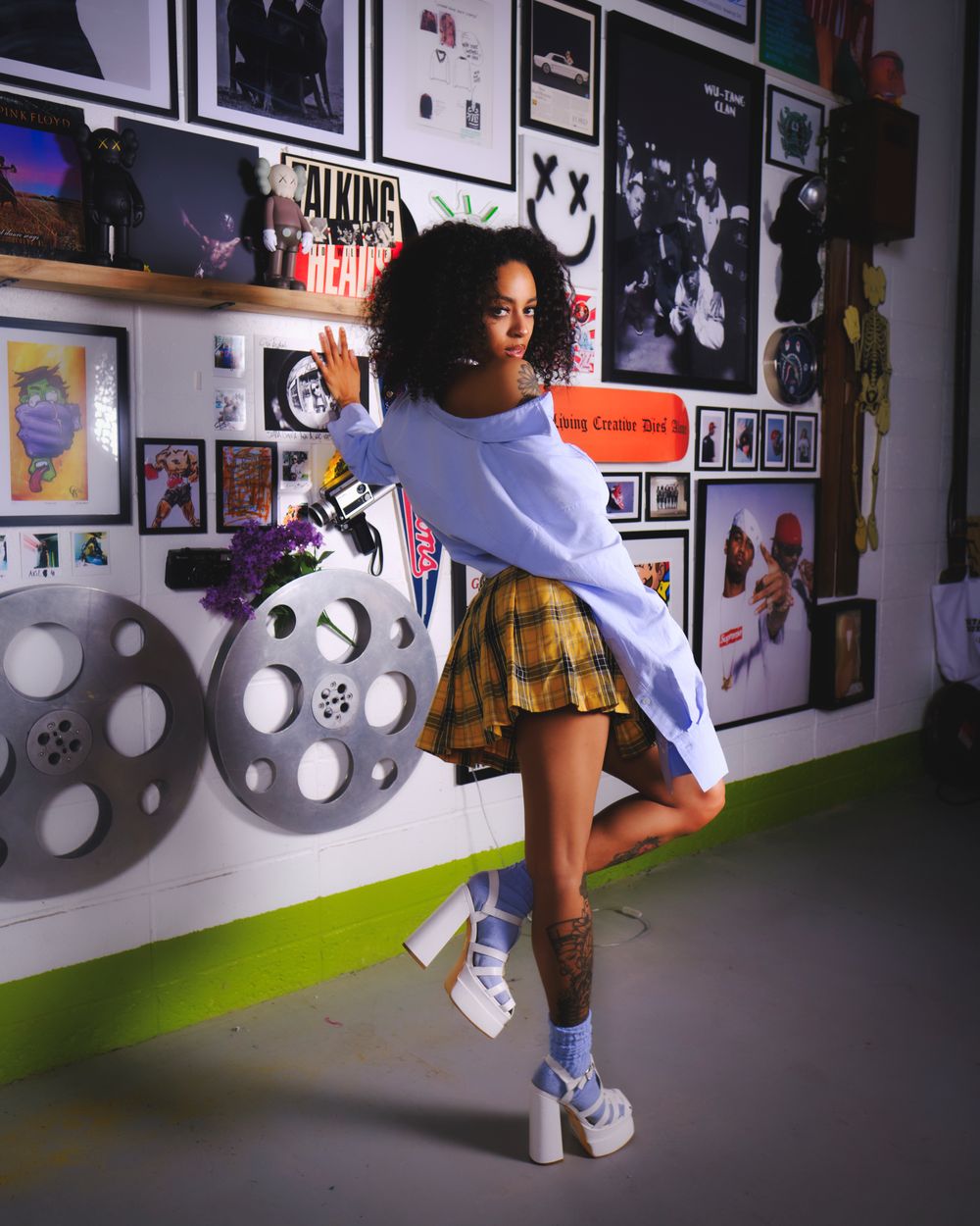 Dynamic fashion shot with film reels and posters showing movement in white outfit.
