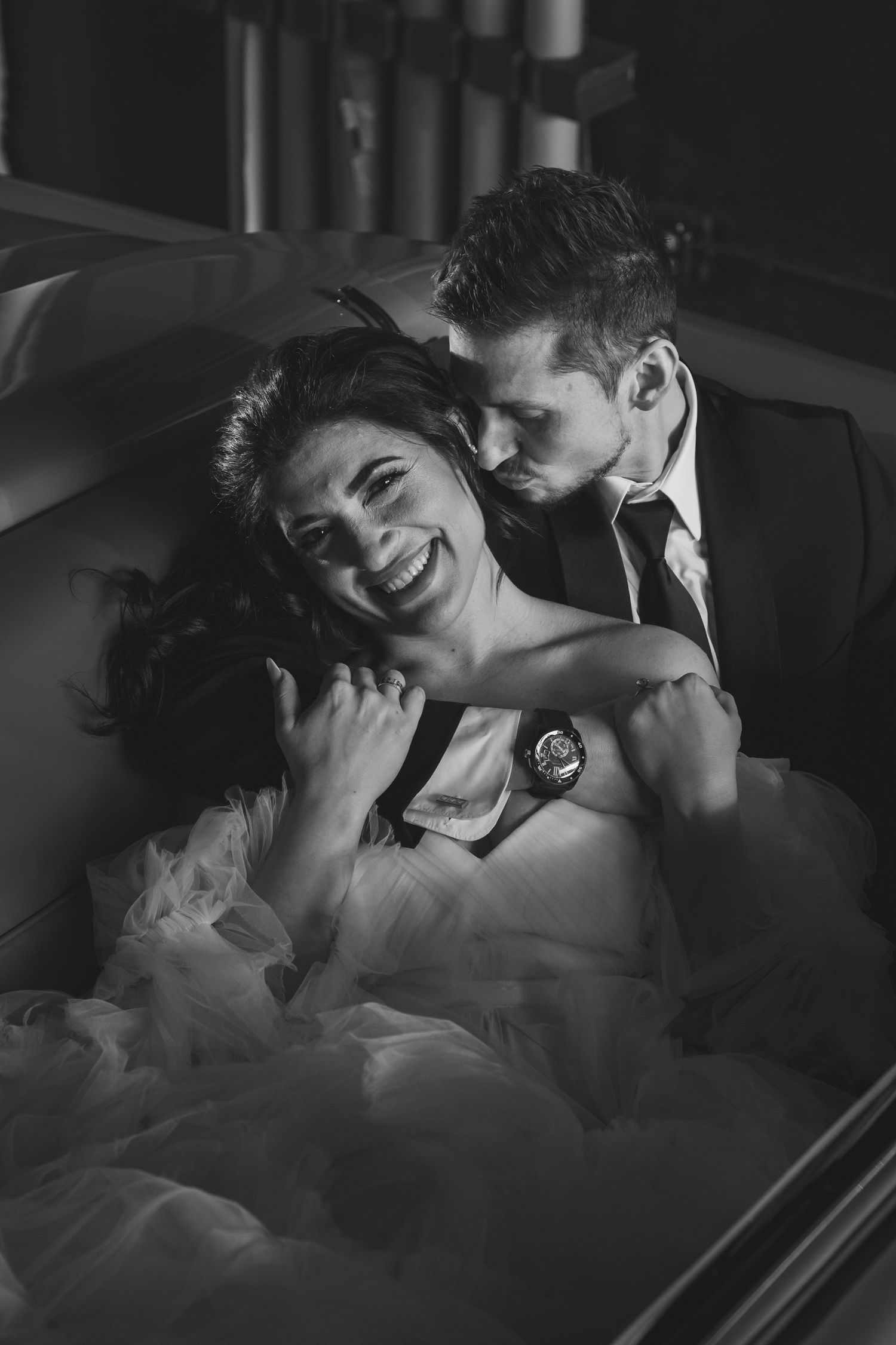 An intimate black and white photo capturing a romantic moment in formal wear.