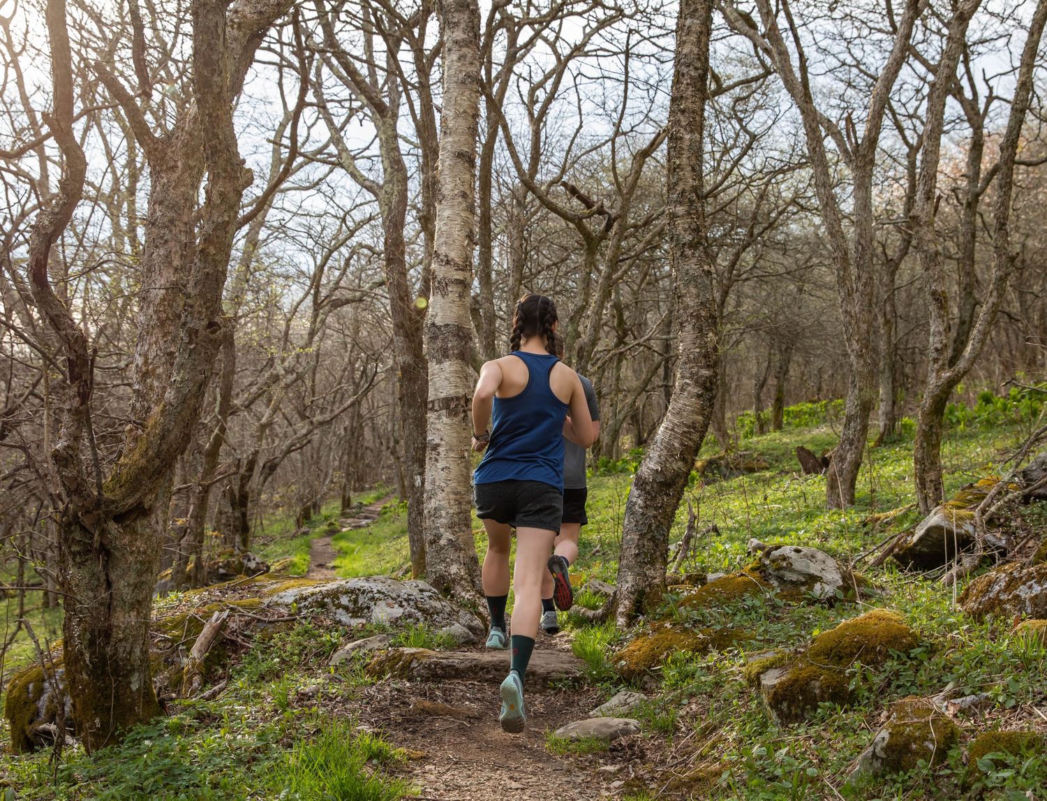 Photo of a woman running on a trail wearing Run Strong socks, Whitetop Mountain, Virginia