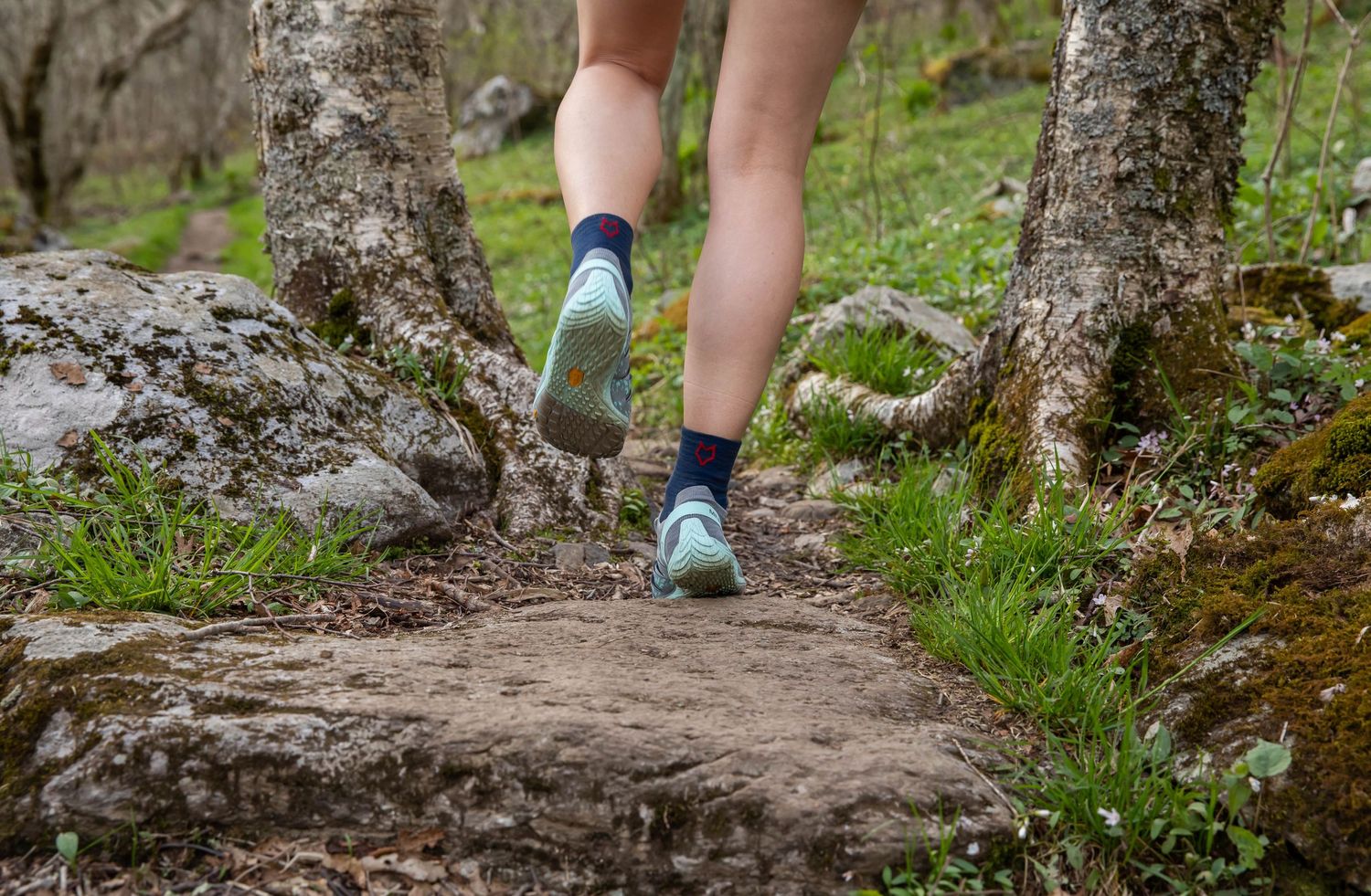 Photo of a woman running on a trail wearing Run Strong socks while running on a trail on Whitetop Mountain, Virginia