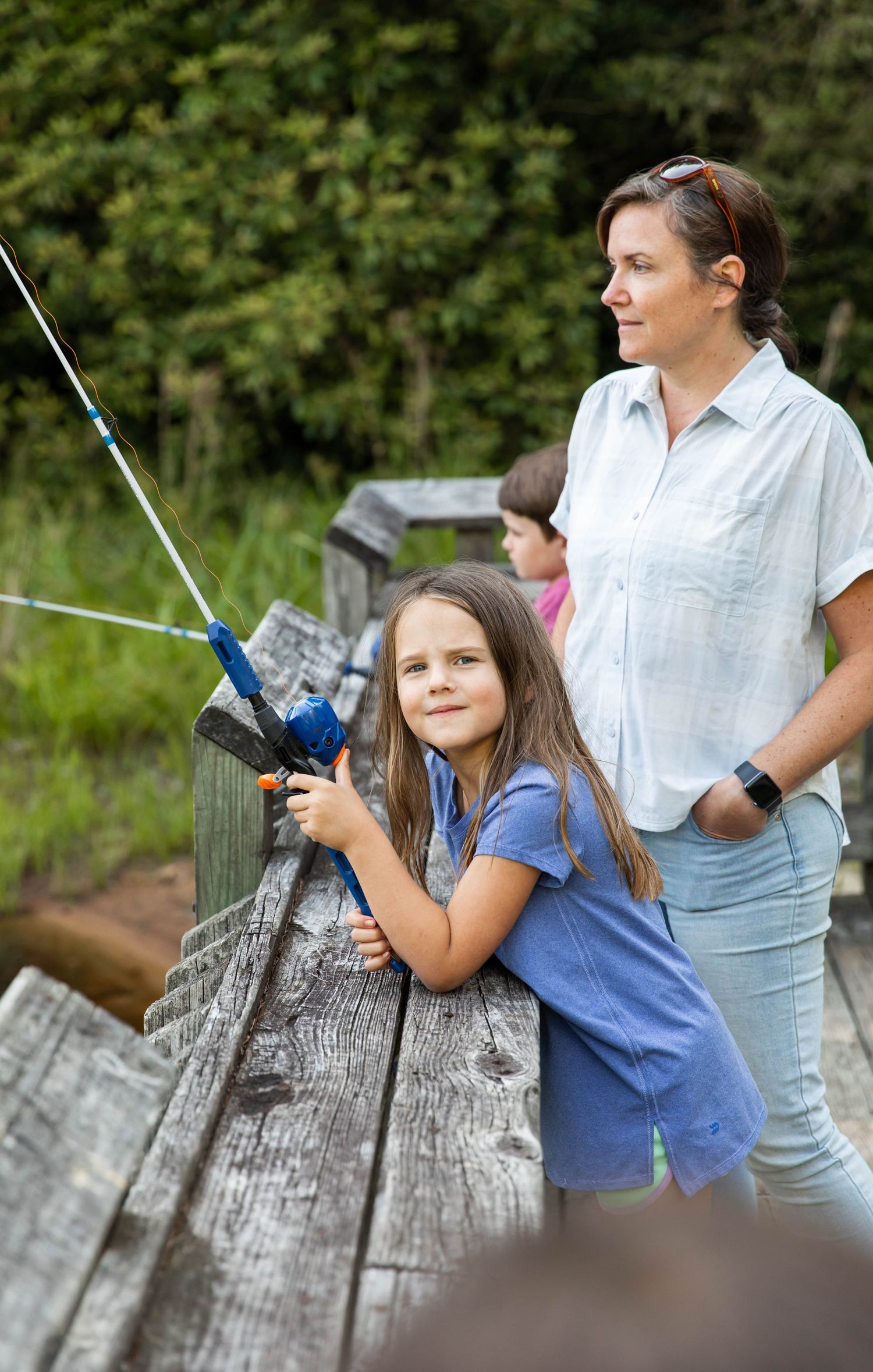 Photo of a mother and daughter fishing at the lake with Zebco reels