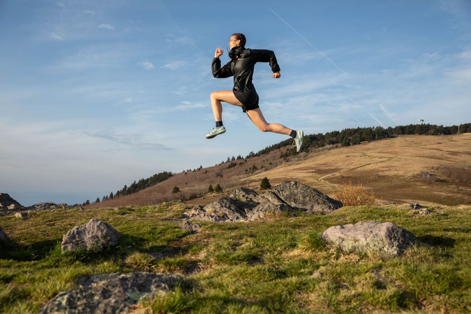 Photo of a woman jumping across rocks on Whitetop Mountain, Virginia