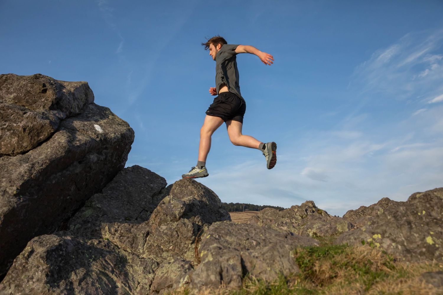 Photo of a man jumping across rocks on Whitetop Mountain, Virginia