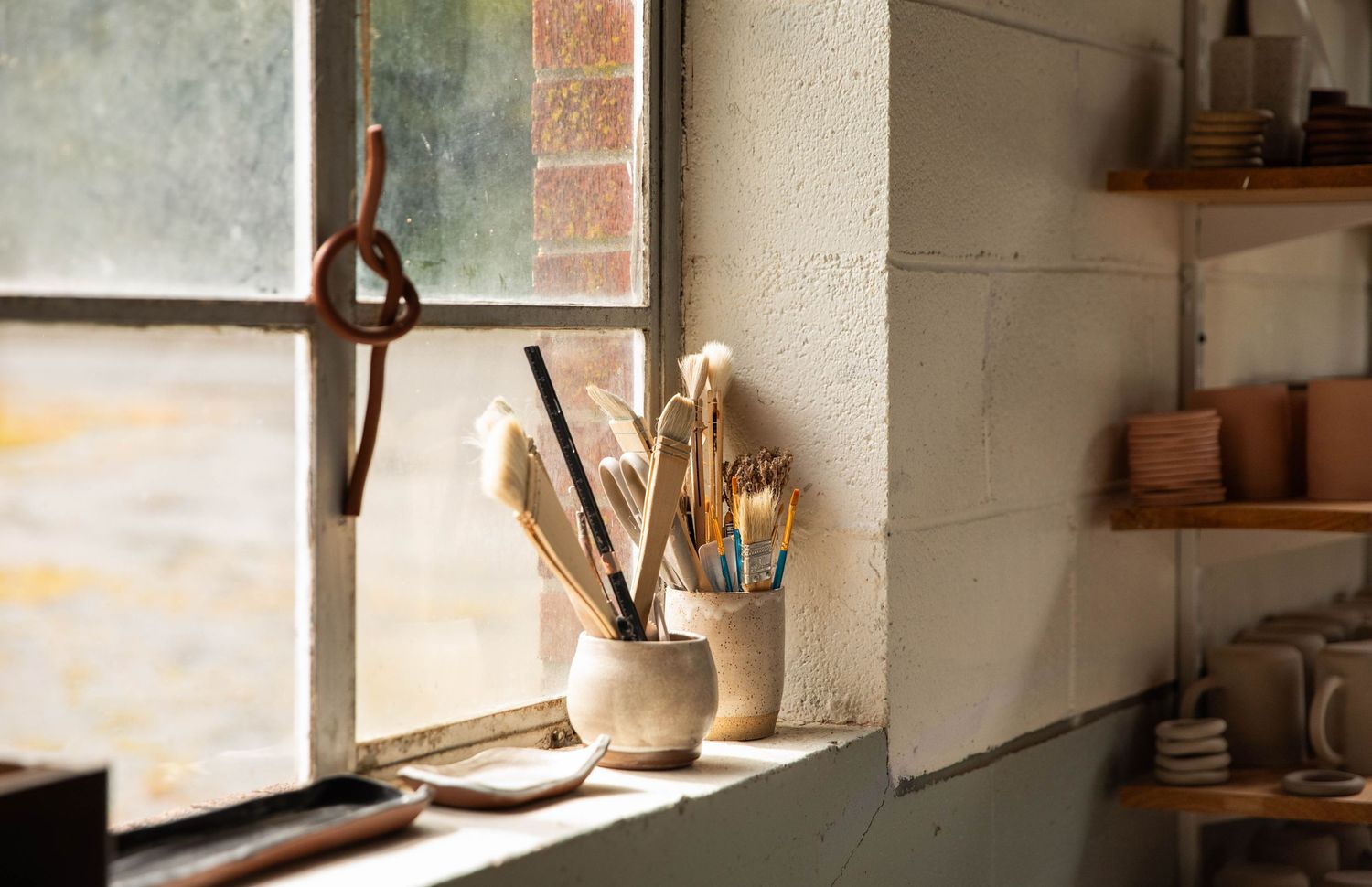 Photo of pottery supplies in a windowsill with pretty light flooding in