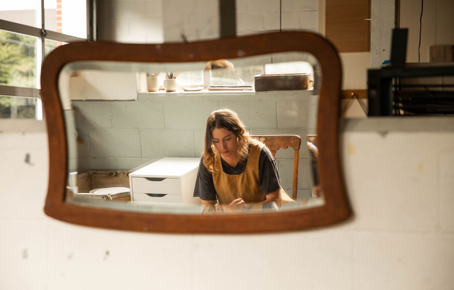 Photo of a potter at work at the wheel, taken through a mirror