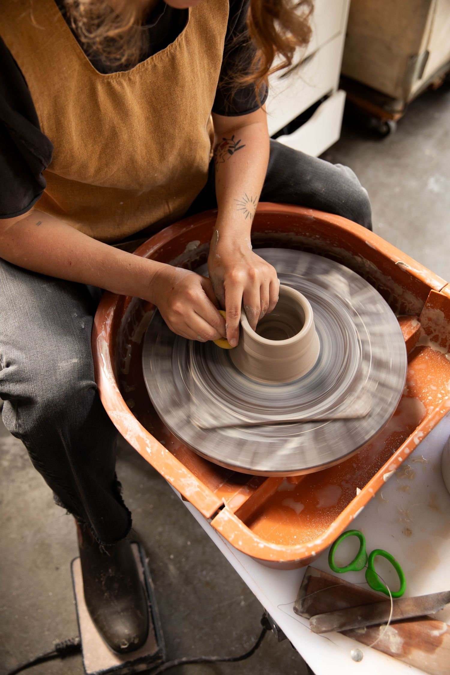 Photo of a potter at work at her wheel in Boone, NC