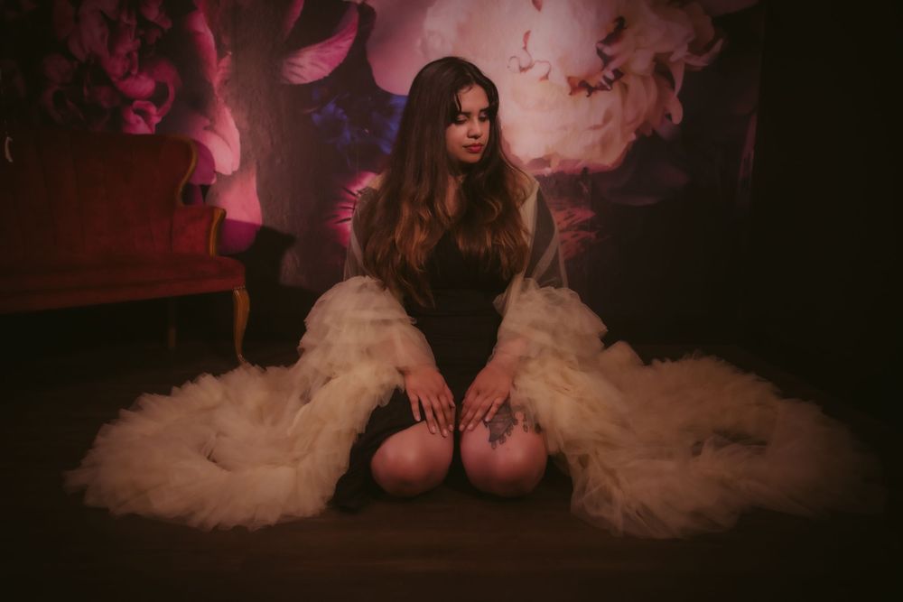Dramatic red-lit silhouettes in formal attire against dark background.