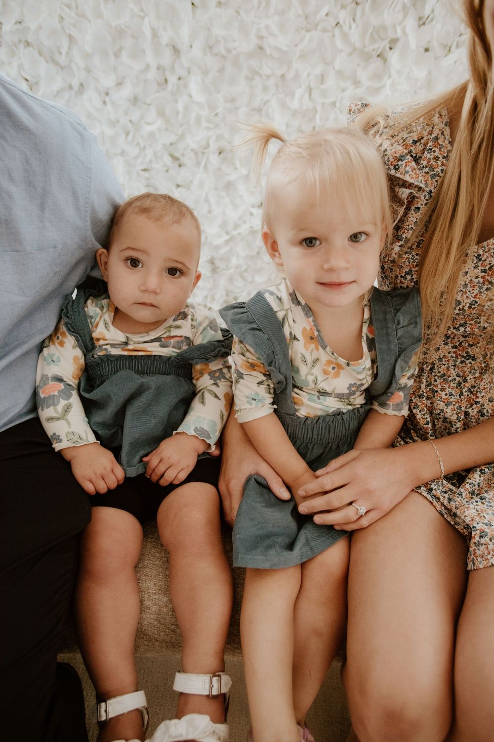 A series of five connected photos showing children sitting together on a couch in matching outfits.