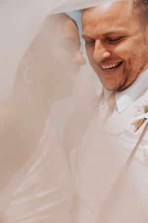 A romantic moment captured through a sheer veil on a sunny day.