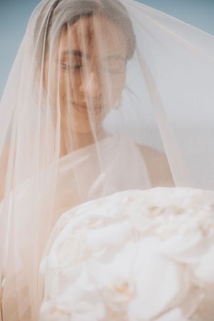 Artistic portrait through sheer wedding veil showing soft dreamy effect.