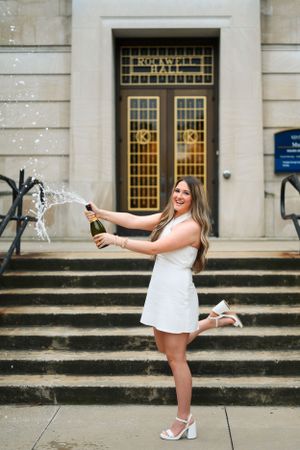 A celebratory moment on stone steps leading to an elegant building entrance with decorative golden doors.