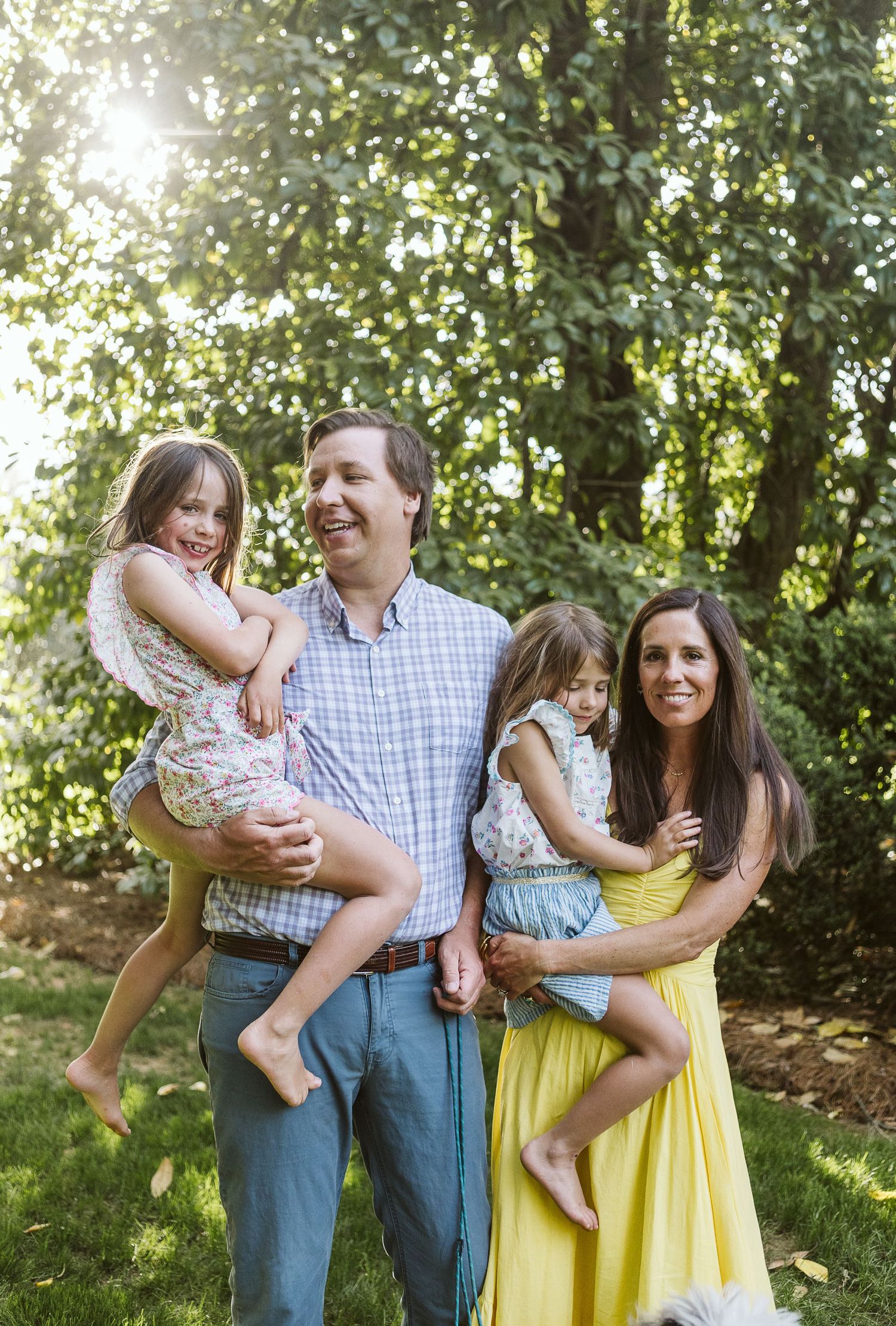 Lifestyle family portrait of parents with two young children in natural outdoor setting