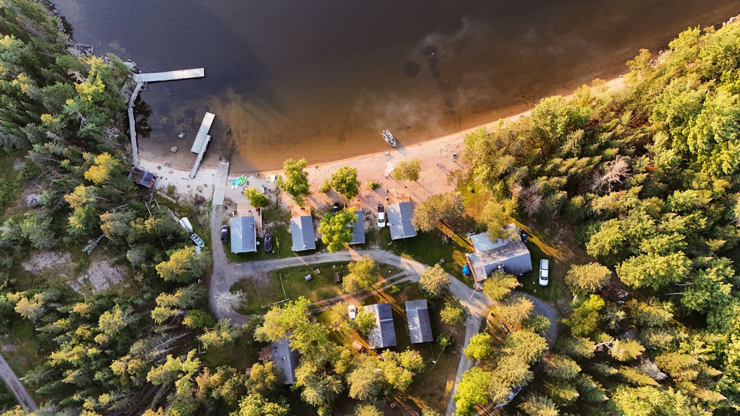 Aerial view of waterfront campground surrounded by lush forest.