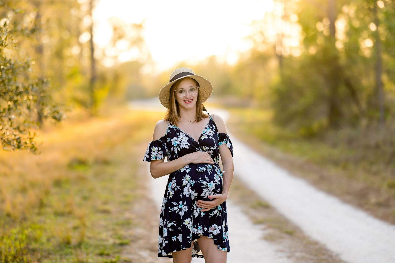 Golden sunlight illuminates wooded trail during sunset photo session.