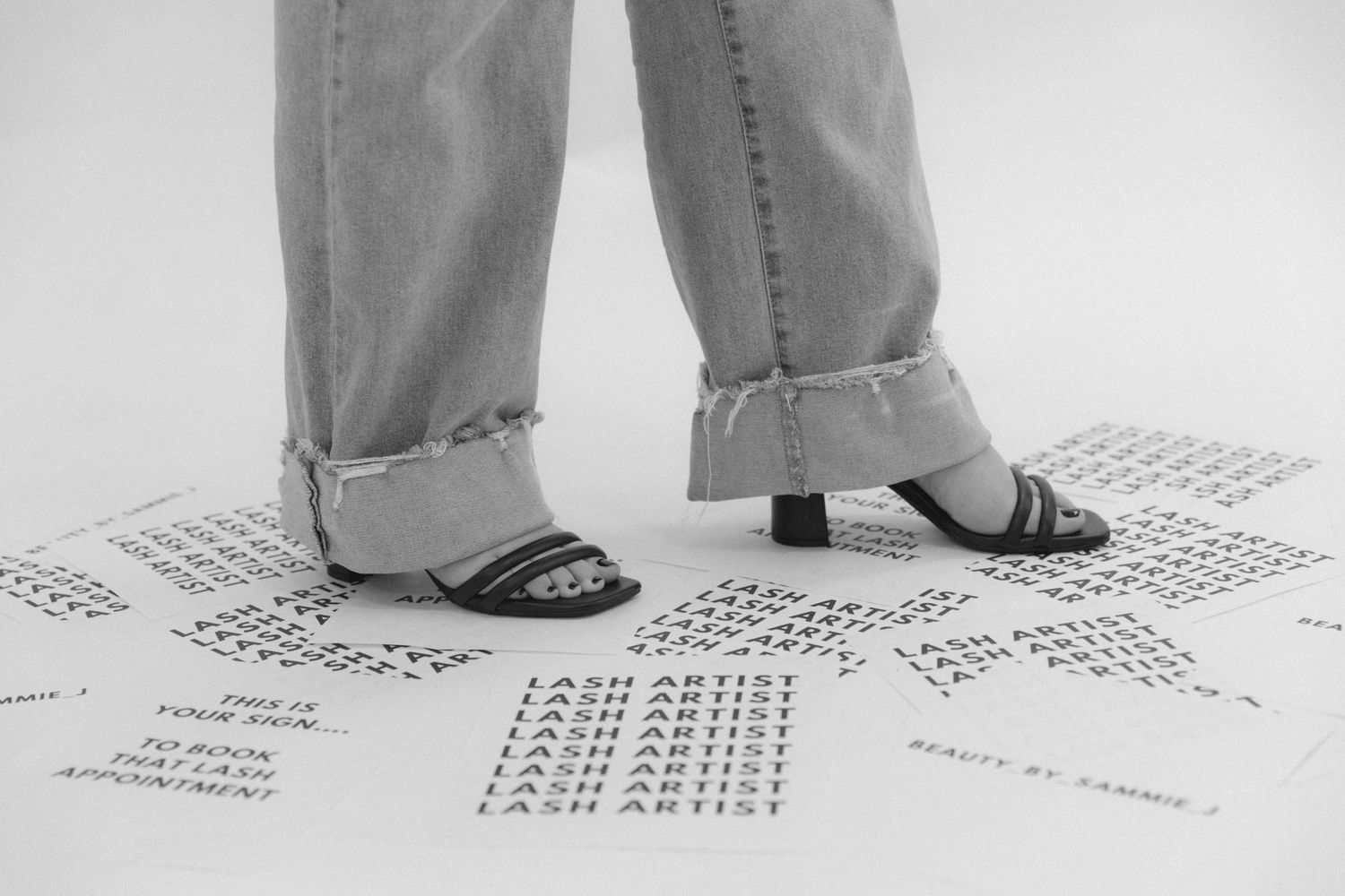 Close up of feet standing on foot placement markers on grey ground.